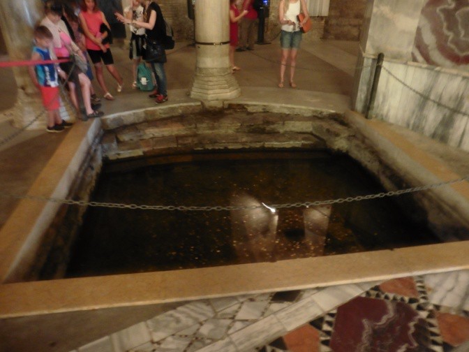 A roped off area with people looking down into a hole.