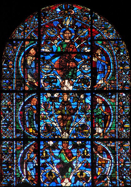 The top of the window also holds three stacked stories, but the top one is of Christ and is pointed as it is the top of the arch. Refer to the text for details.