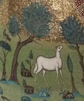 A sheep stands between stylized trees.