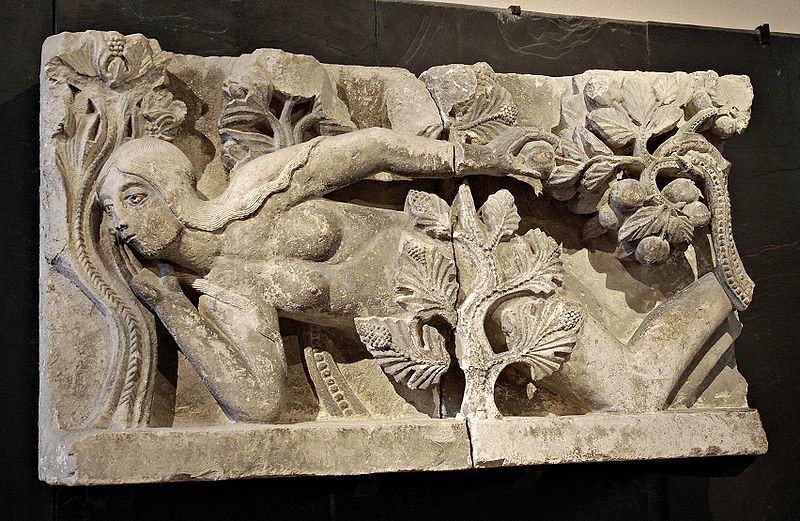 A carving of Eve in the nude with her crotch covered by a tree. Refer to the text for details.