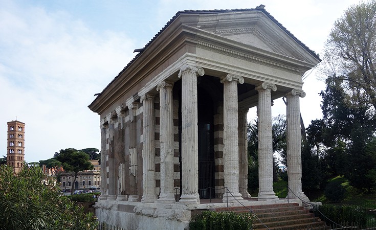 A temple with a porch supported by ionic columns. It sits on a pedestal and has a pediment and steps leading to the porch.