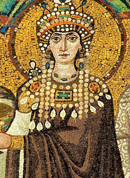The Empress is elaborately dressed in jeweled clothing and crown. She has a halo.