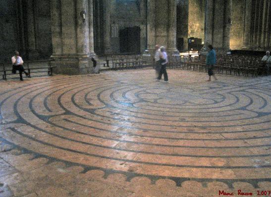 A photo of people walking on the labyrinth that covers the floor of part of the cathedral. Refer to the text for details.