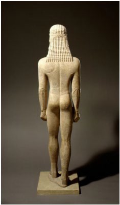 The back view of a nude kouros statue with plaited hair.