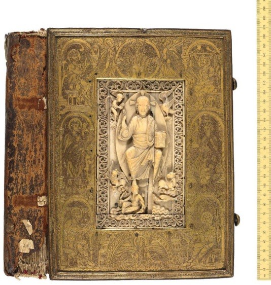 A leather manuscript cover with a carved ivory image of Christ in the center.