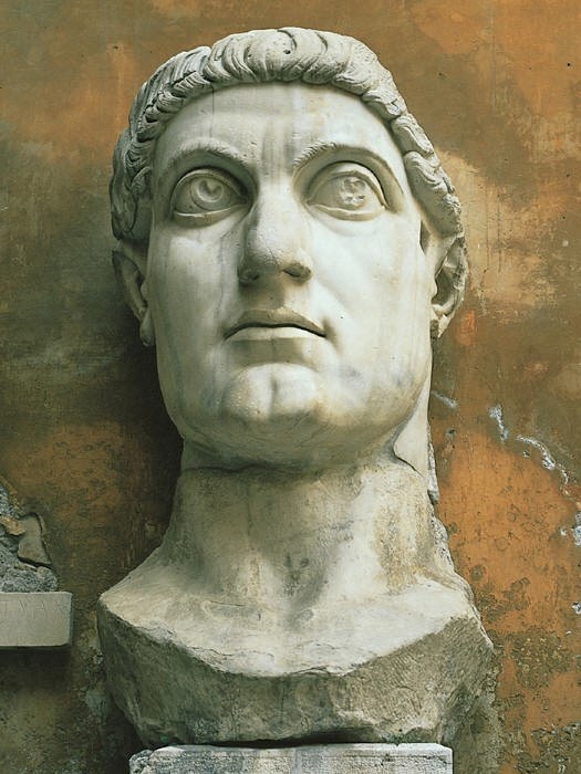 A huge marble head that has the look of a superhero. It has a strong jaw and huge deep-set eyes.