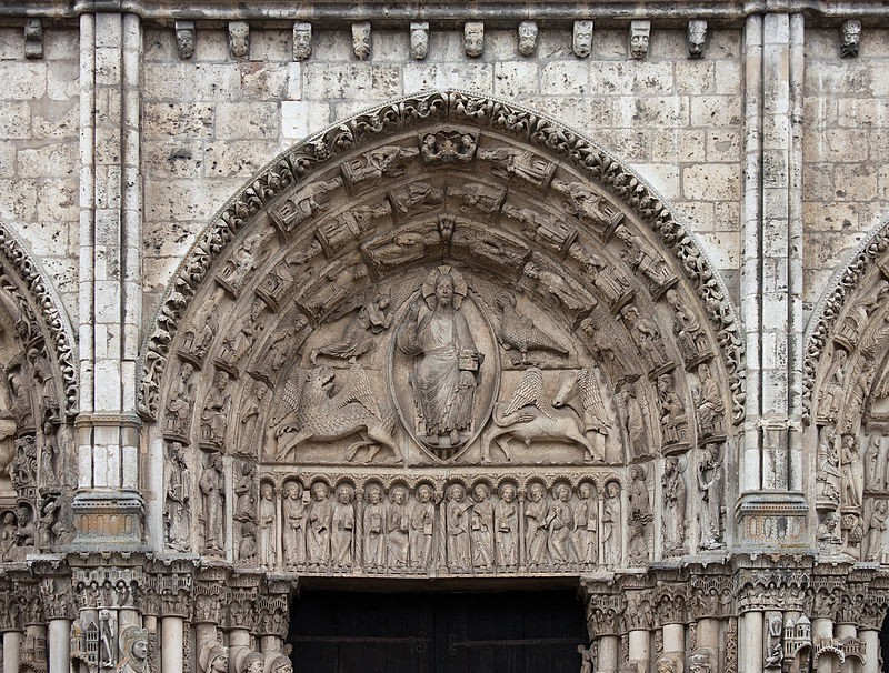 A close-up of a tympanum. A rather stiff Christ is in the center of a body halo with the symbols of Mark, John, Luke and Matthew around him.
