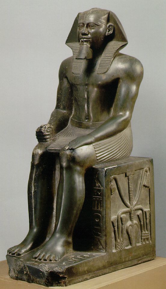 An idealized granite carving of Khafre, an Old Kingdom ruler, where his spirit (ka) could reside in during mummification. Rock carving of the seated Khafre.
