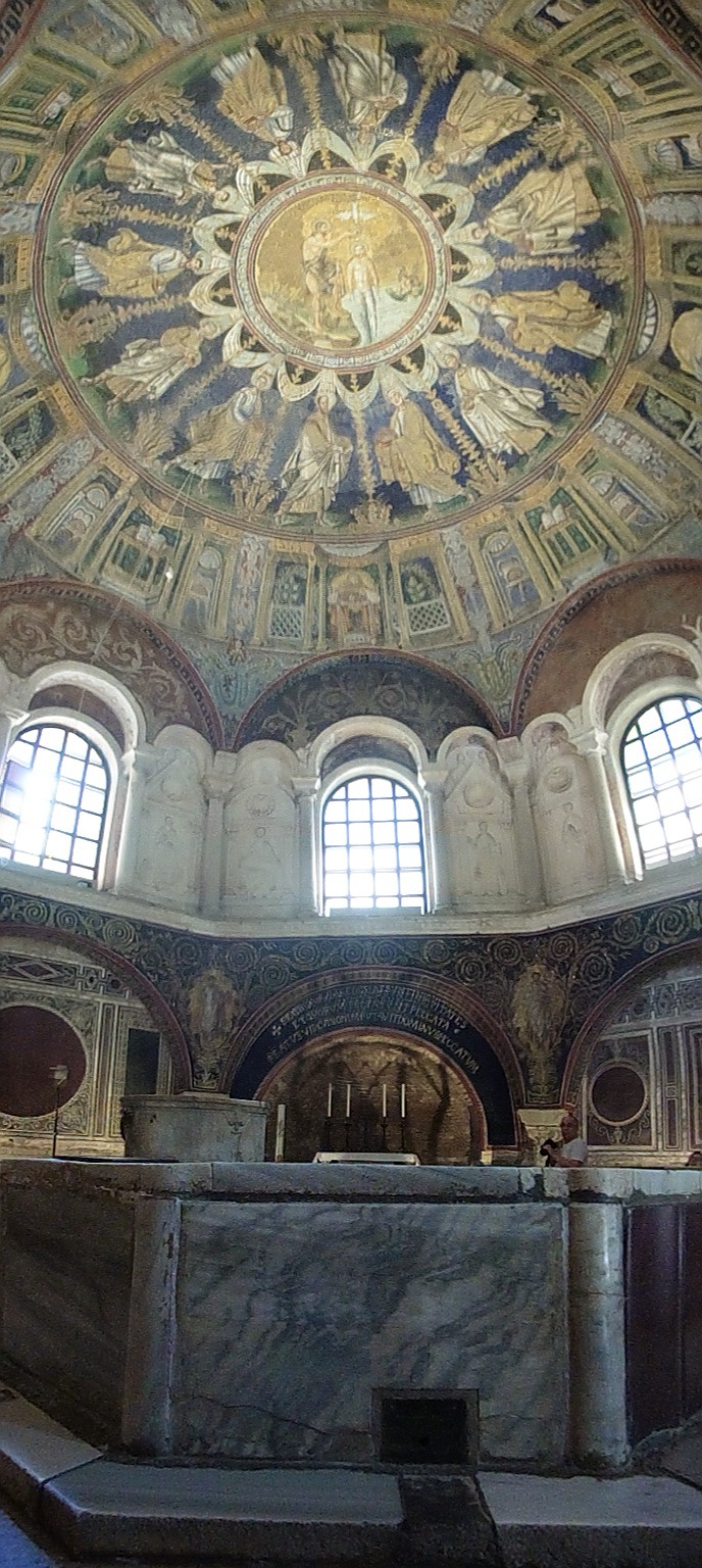 The interior view of the ceiling. The ceiling is decorated in a wheel pattern with saints as spokes. The saints are in motion and seem to be stepping in different directions.