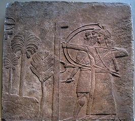 A bas relief showing three stylized figures of men. Two aim bows and another holds a knife.