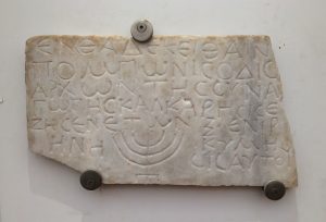 A carving of Hebrew words and a minora.