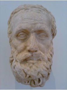 A marble carving of a beaded old man’s head.
