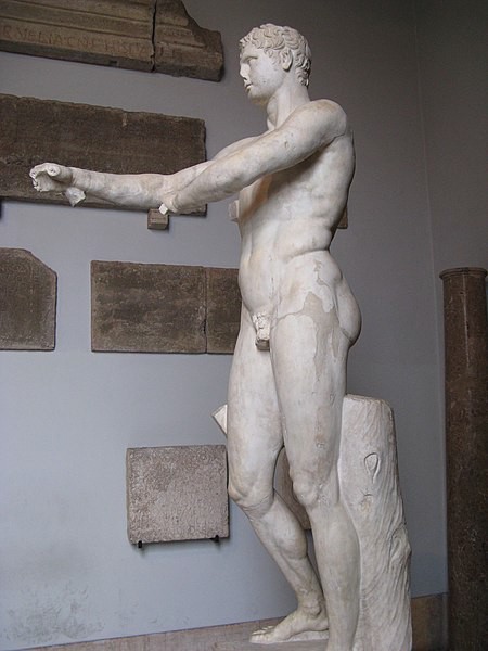 A tall, lean nude man scraping the olive oil from his body.