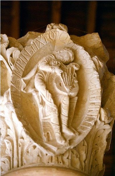 A capital depicting a man playing an instrument.