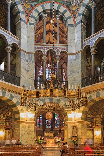 A photo of the elaborate three tier interior of the chapel. Matched marble, gold, and alternating stonework are incorporated.