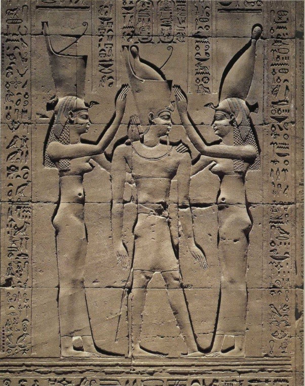 Carved image of two goddesses crowning a New Kingdom ruler. Hieroglyphics run around the image.