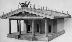 A scale model of a small temple with statues on the gabled roof.