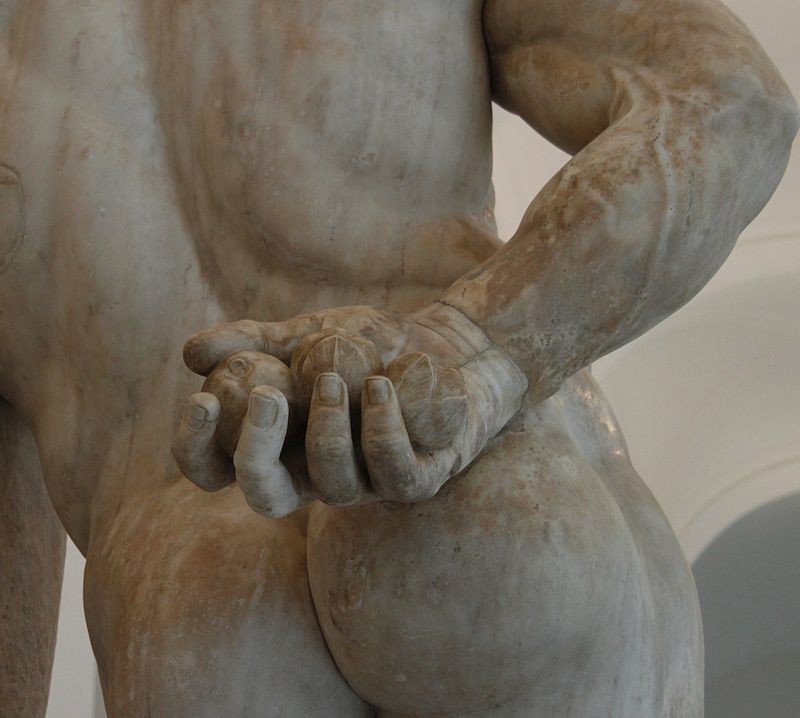 A close-up of apples held in the hand that is behind the figure’s back.