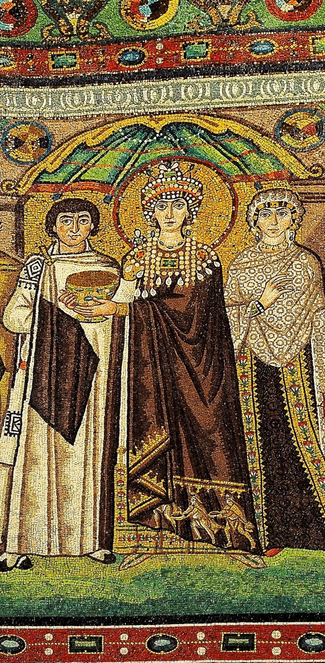 The Empress wears a crown and halo. She holds a chalice with which to do the ritual where wine turns to the blood of Christ, to be performed at the altar. She stands under a dome and is surrounded by her retinue.