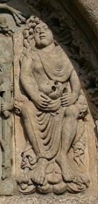 A carving of a sad woman holding a skull in her lap.