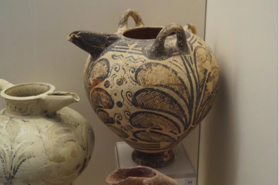 Two large pots with handles and spouts. Geometrically rendered foliage covers them.