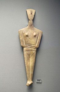 A symbolic stone figure carved from white stone. It is made up mostly of triangles.