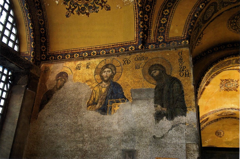 Christ is in blue and holds a book. There is writing above and around him.