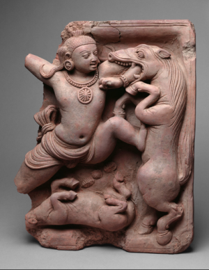 A man shoving his arm into the mouth of an animal that looks like a cross between a horse and a dragon.