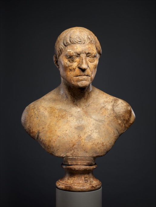 A bust carved of a middle-aged man with short haor and no cloak.
