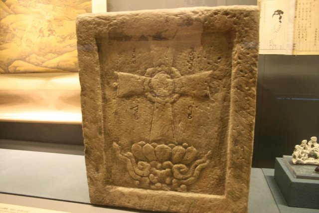 A Celtic style cross carved into a rectangular block of stone.