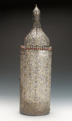 A bottle-shaped object covered in incised silver with coral decoration just below where the bottle narrows.