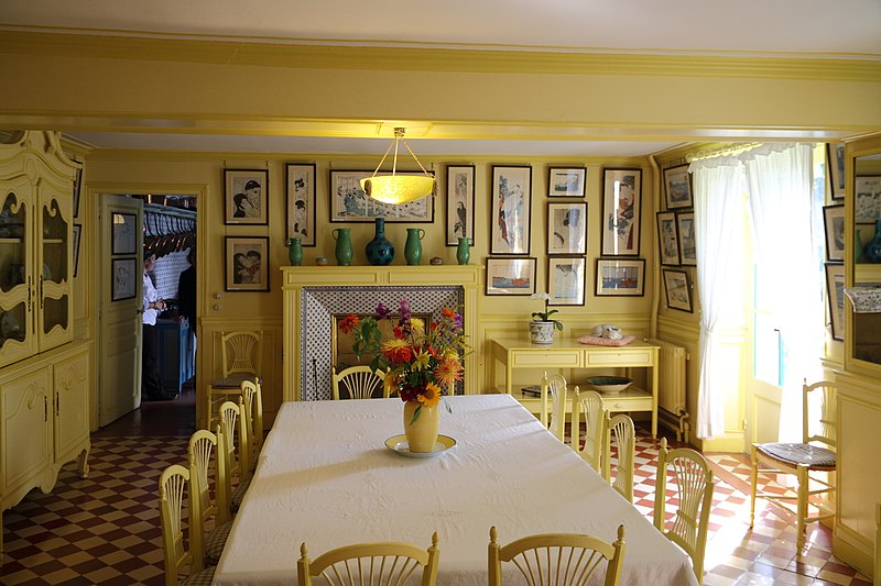 Photograph of yellow dining room with cream and red checked floor tiles, Giverny, Monet’s home near Paris.